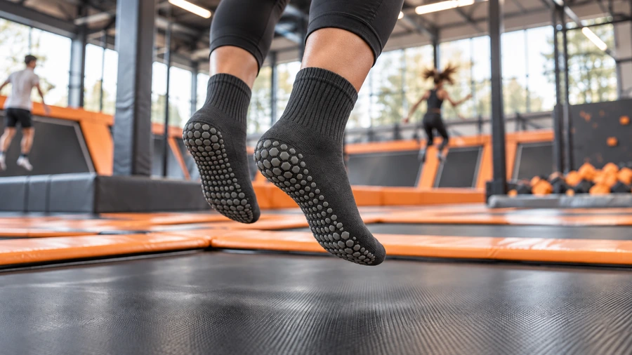 Closed-toe crew socks with patterned silicone sole grips in a trampoline activity park